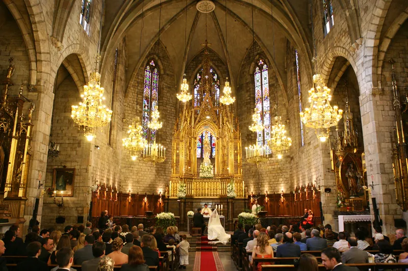 Ceremonia en una iglesia gótica iluminada con lámparas de araña