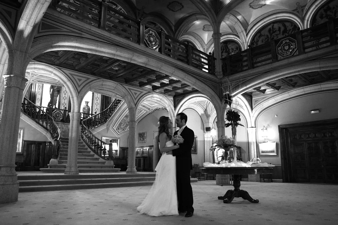 Pareja de novios en blanco y negro en el vestíbulo de un palacio modernista